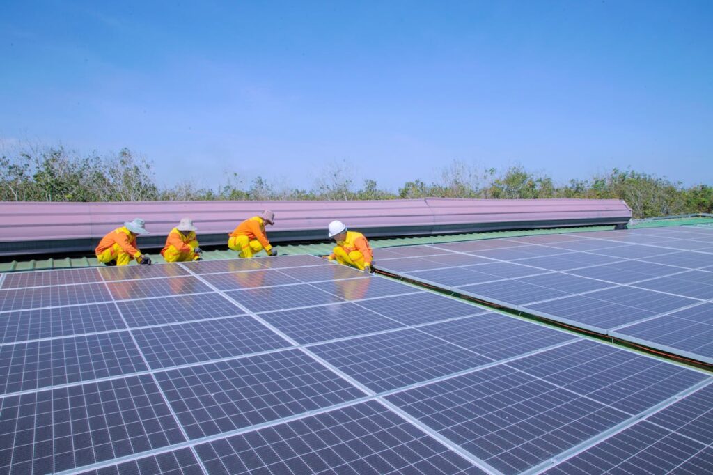 Workers installing solar panels on a sunny day, promoting renewable energy and sustainability.